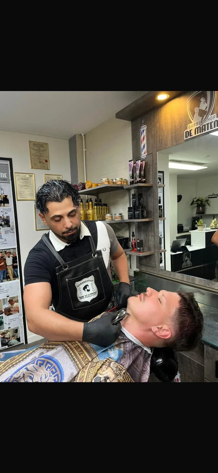 Daniëls scheert een klant met aandacht bij Barbershop De Maten in Apeldoorn